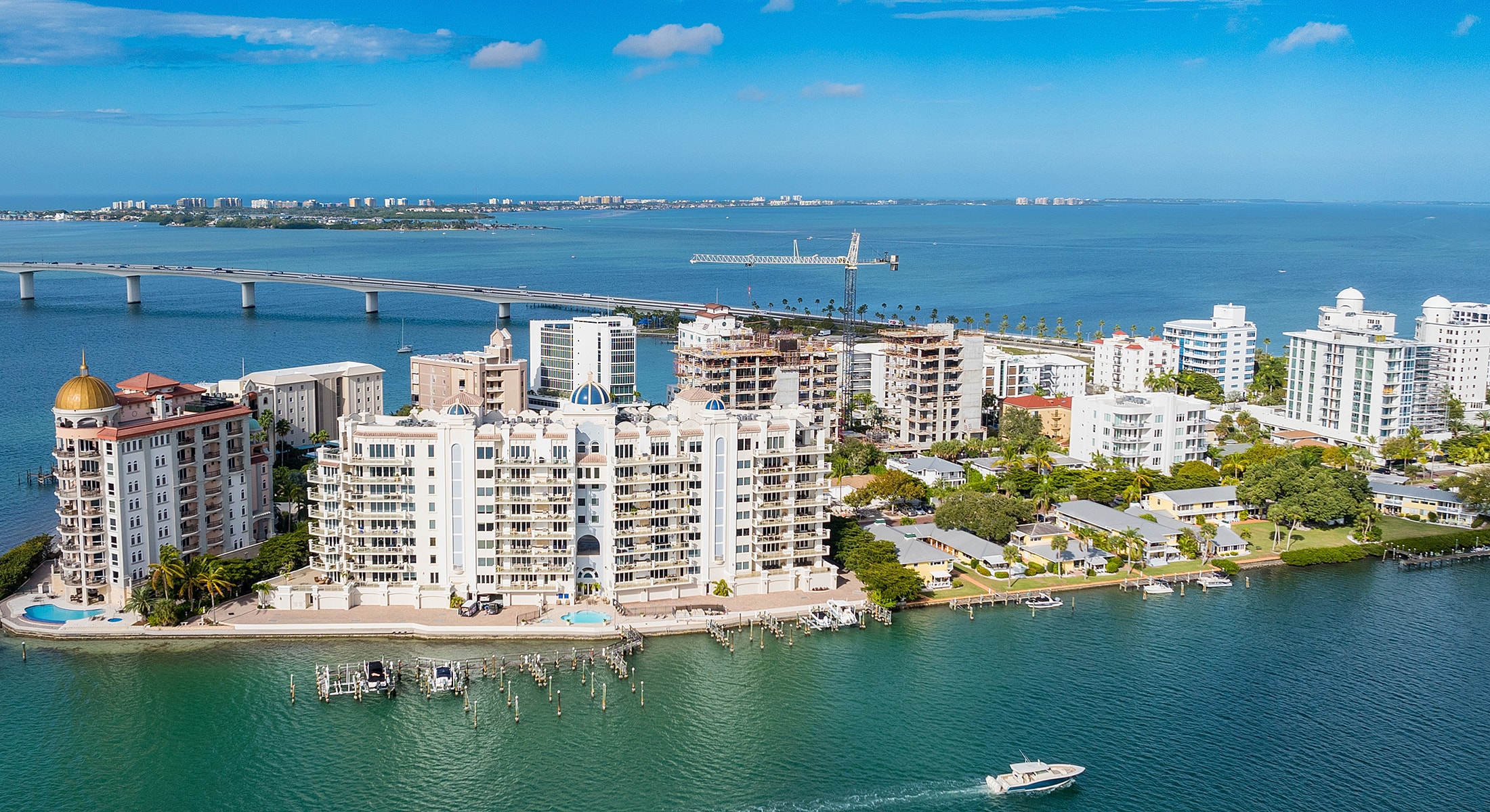 Coastal city skyline along clear blue waters.